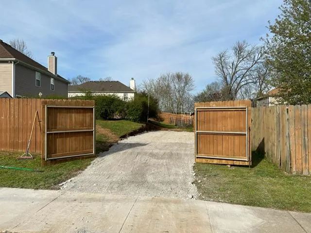 Curved residential gravel driveway through a wooded property